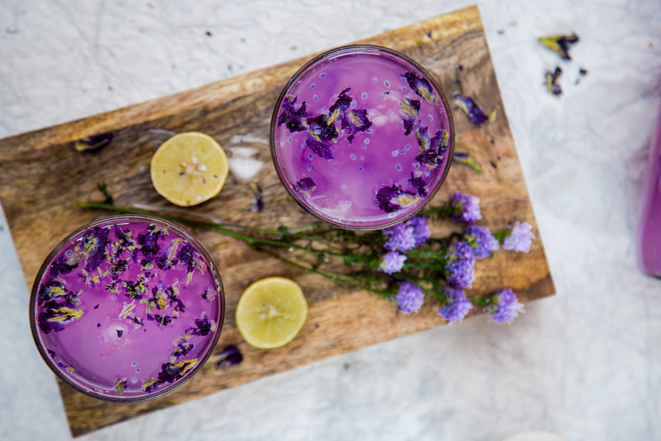 Fresh Lavender Drink with Lemon and Lavender Flowers. Cold Summer Violet Lemonade, Top View on a Wooden Board.